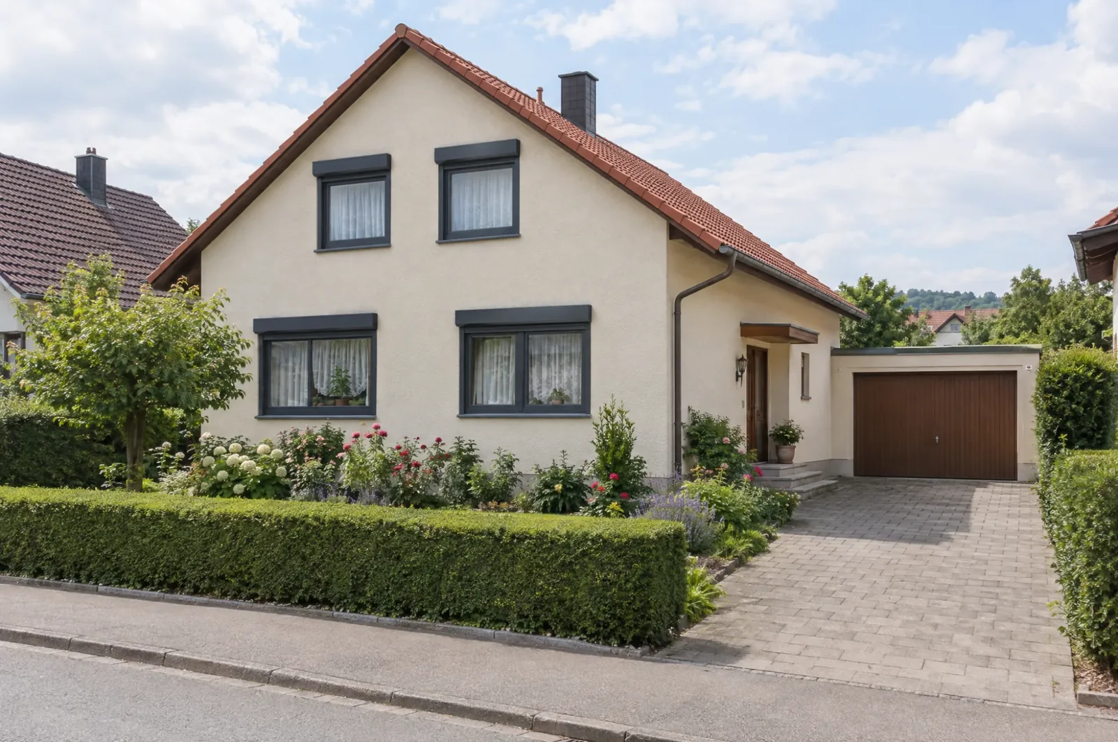 Nachher: Einfamilienhaus mit neuen anthrazitfarbenen Fenstern und Rollläden